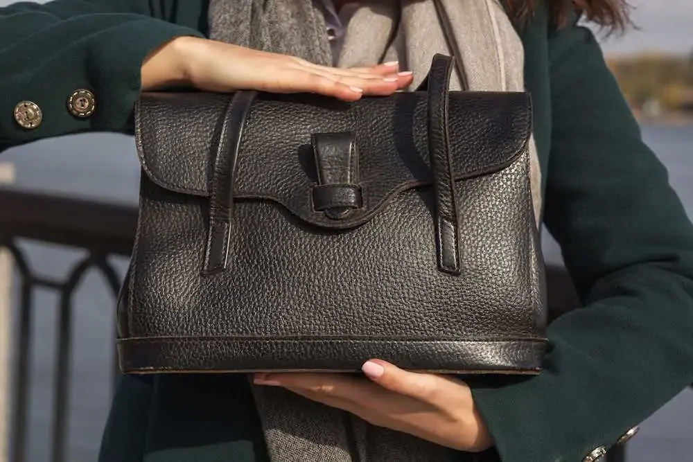 Woman holding a dark brown PU leather handbag