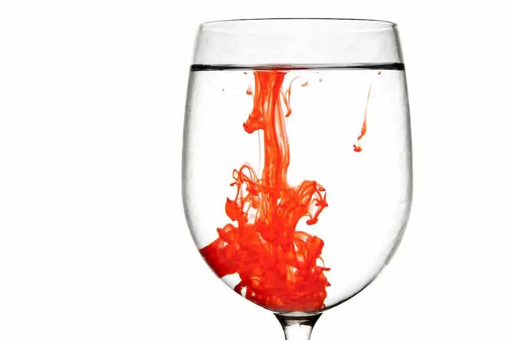 glass of water with red carmine coloring through it