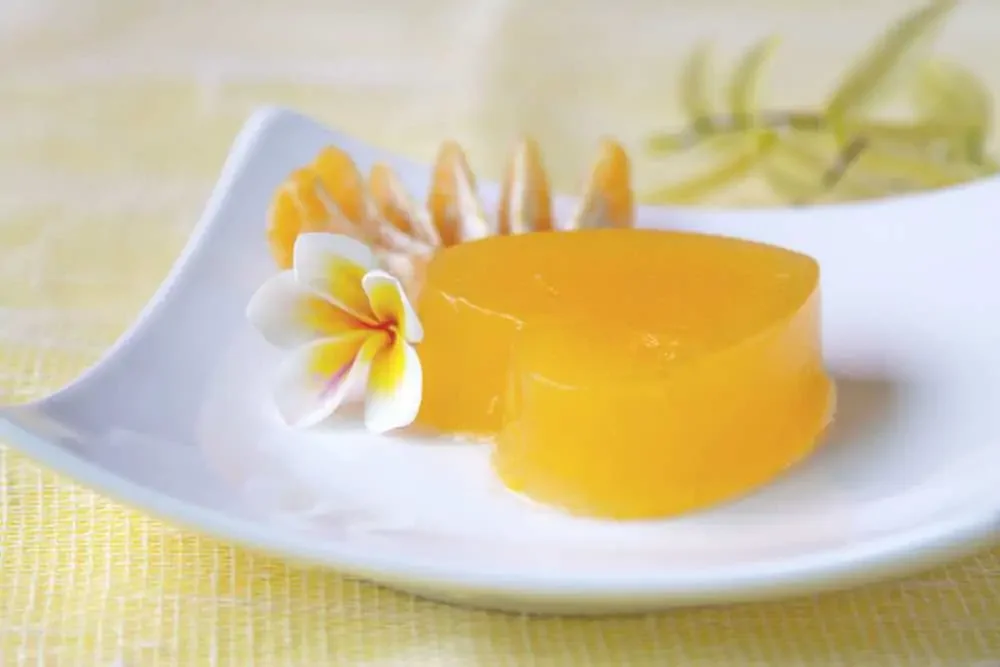 orange vegan jello heart on a white plate with flowers
