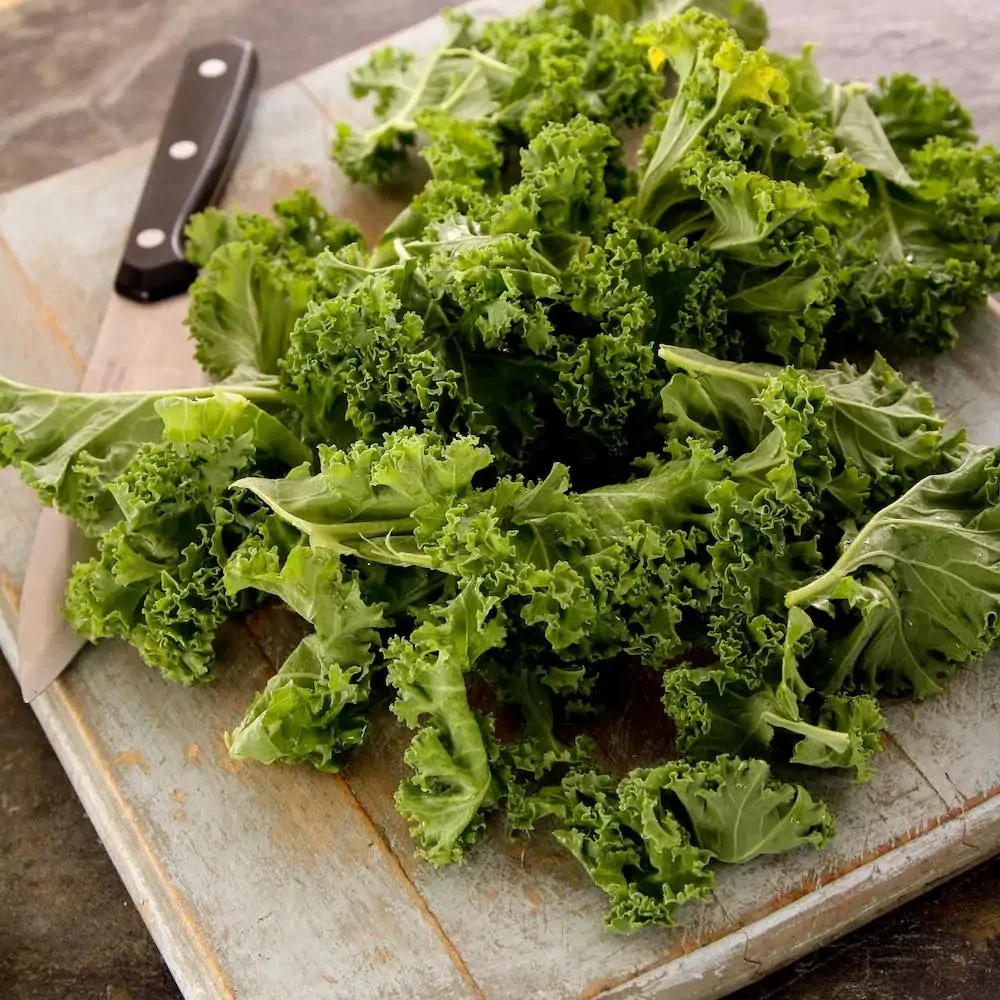 kale leaves on a chopping board with knife ready to be prepared
