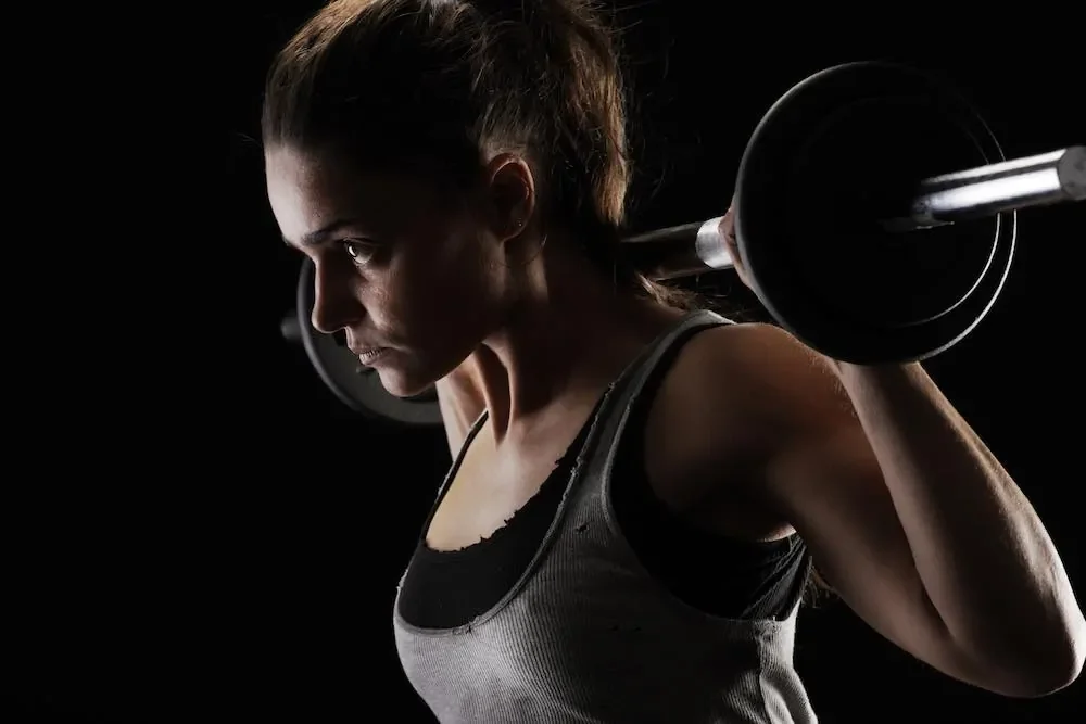 woman with barbell takes best bcaa powder for vegans